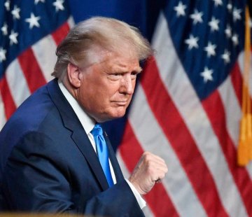 Photo de Donald Trump avec le poing levé devant le drapeau américain